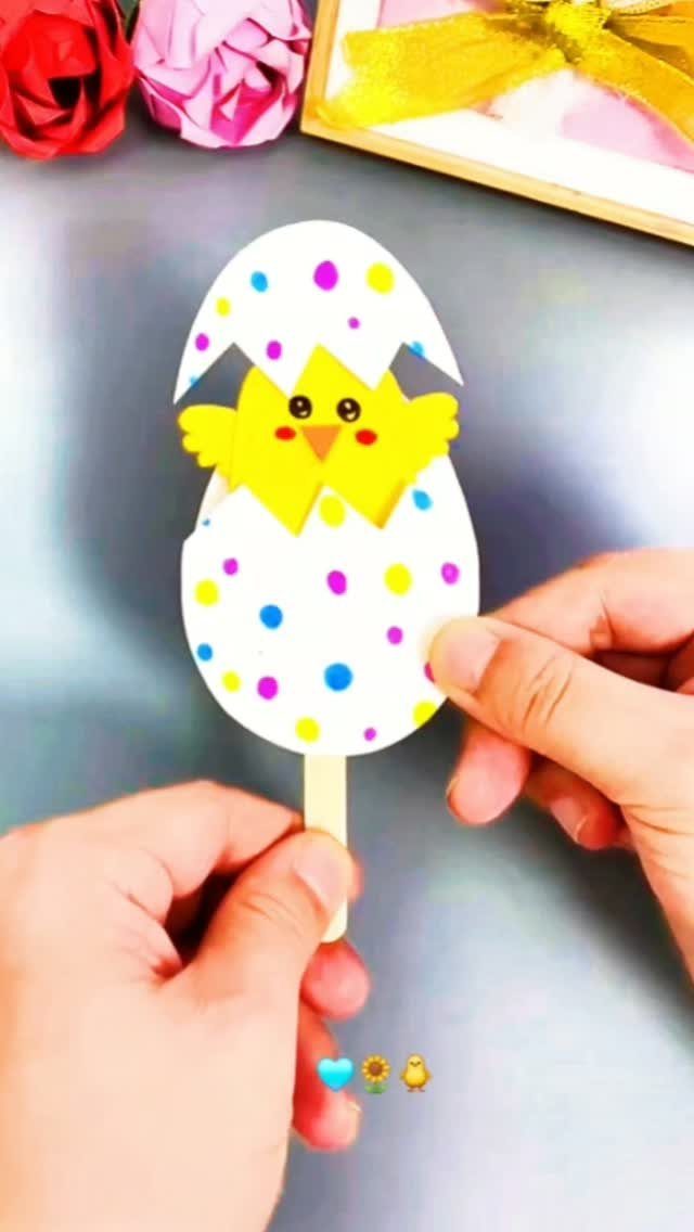 Paper craft of a yellow chick hatching from a colorful polka dot egg.