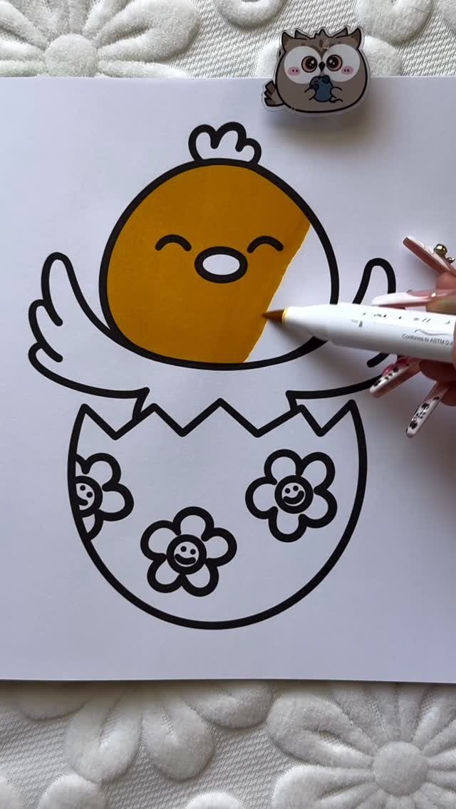 Hand coloring a cute chick in an egg shell on a printable page