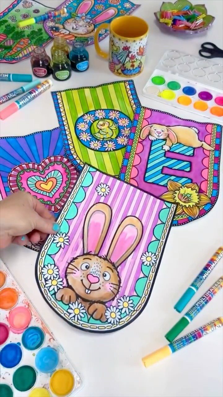 Hand coloring a cheerful Easter bunny page surrounded by markers and paints.