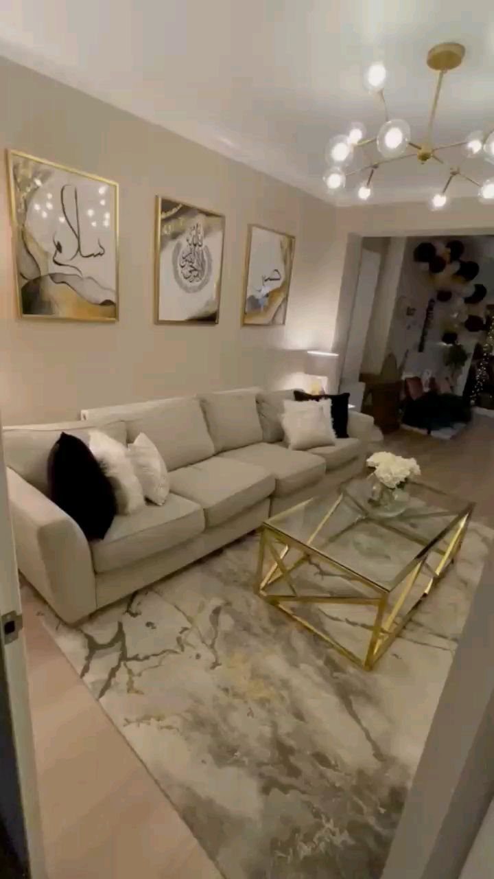 Modern living room featuring gold-framed Arabic calligraphy art on a neutral wall.