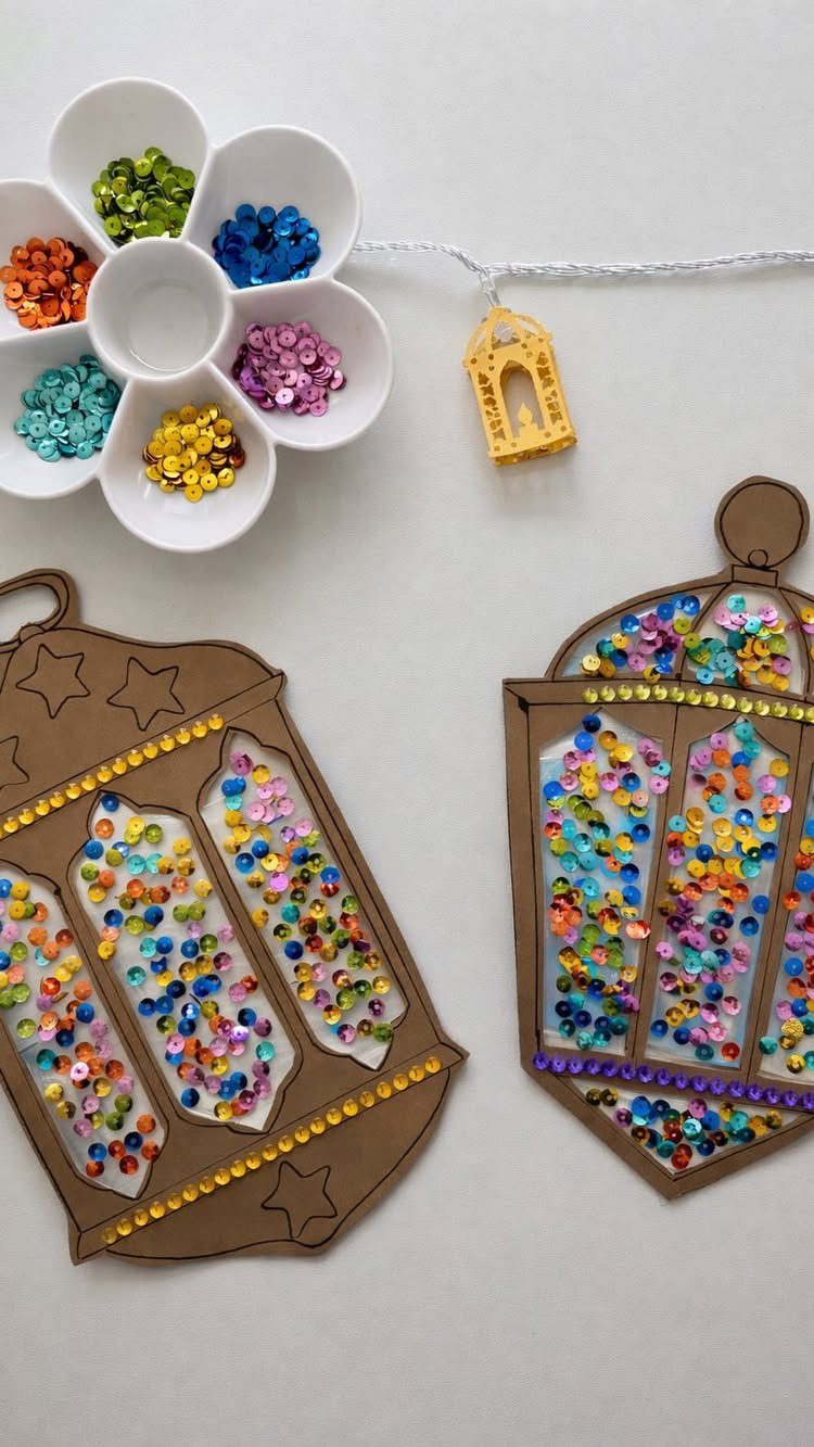 Cardboard lantern cutouts decorated with colorful sequins next to a sequin sorting tray.