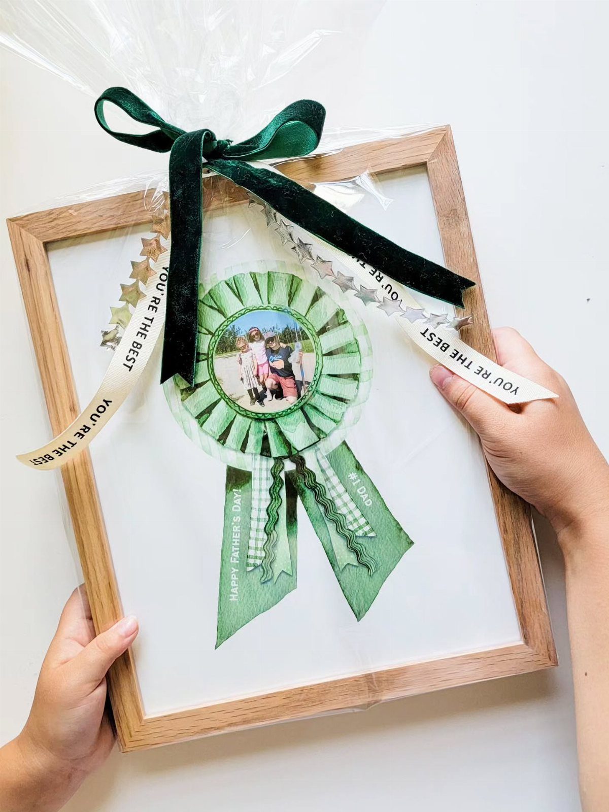 Green paper award ribbon with a photo inside a wooden picture frame