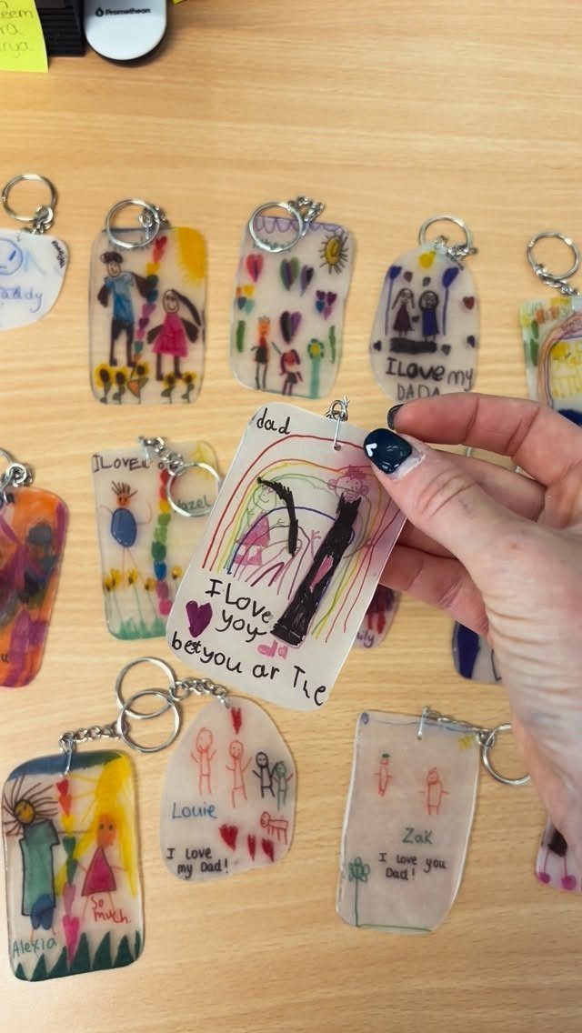 Handmade laminated keychains with children's drawings and messages for Father's Day on wood.