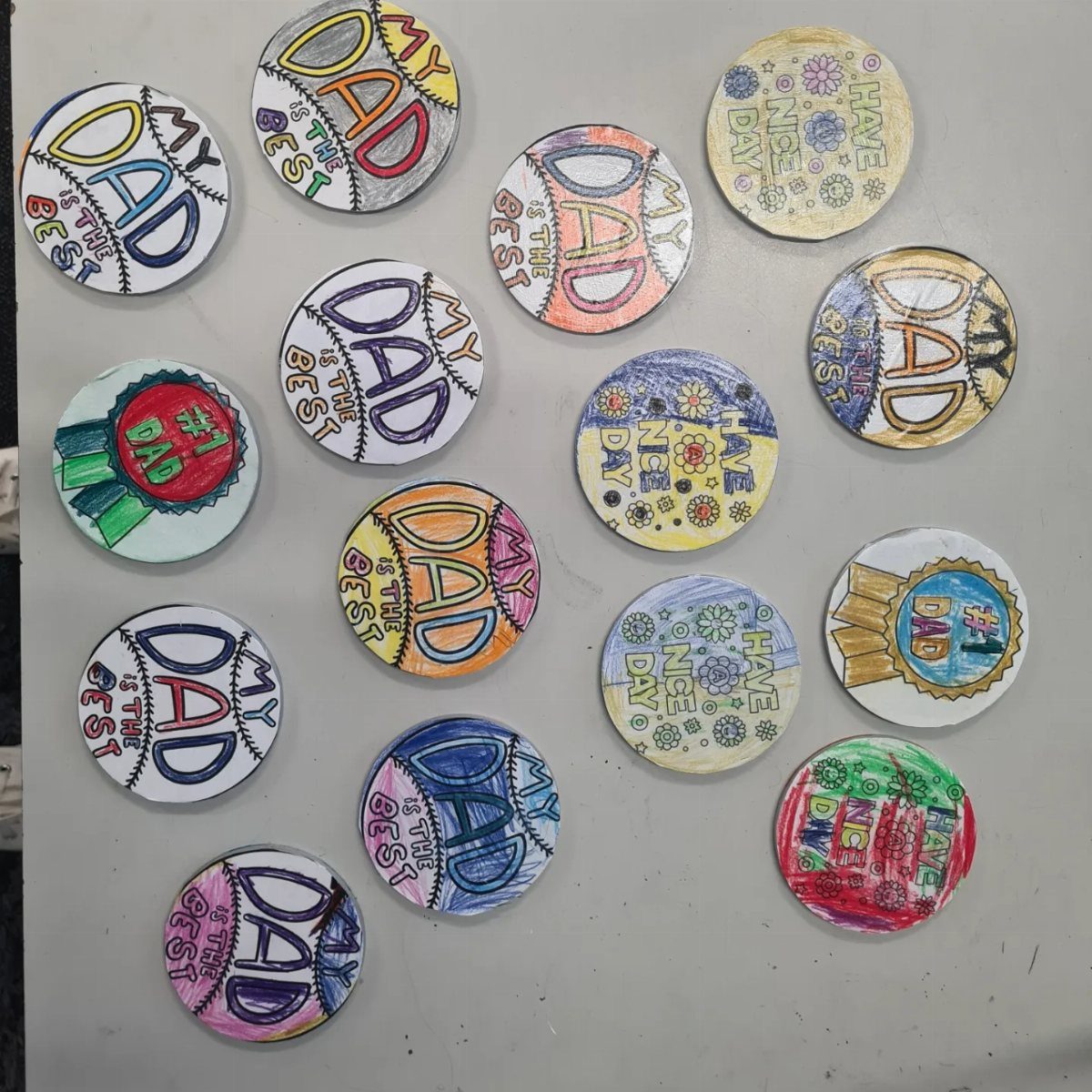 Circular hand-drawn discs with colorful messages for Dad on a grey background
