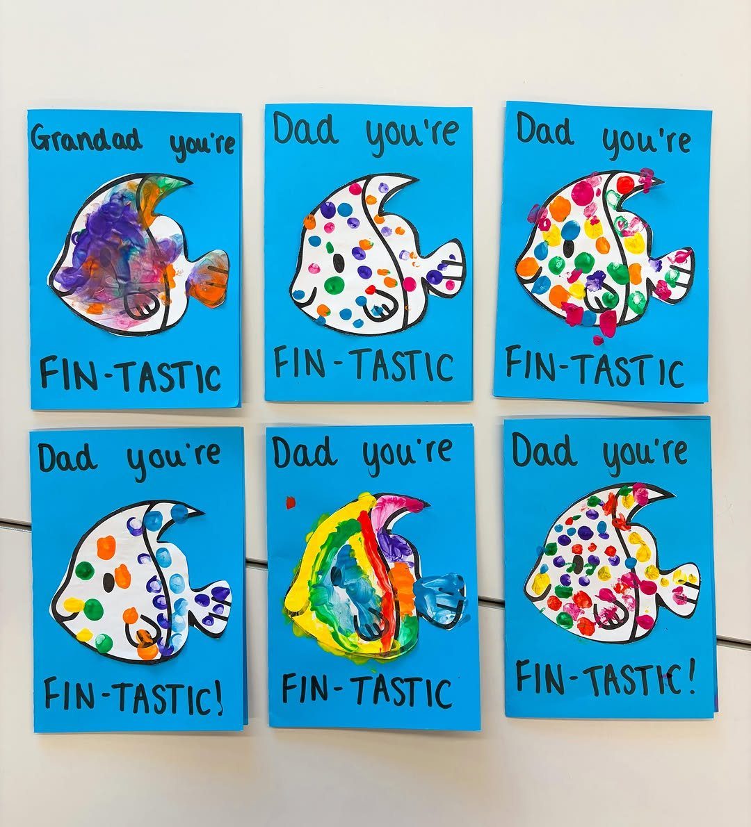 Six blue Father's Day cards featuring colorful painted fish and fin-tastic puns.