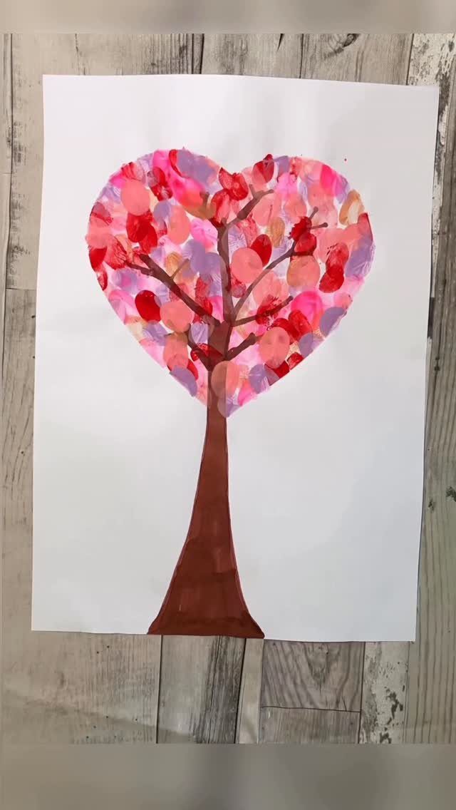 Heart-shaped tree painting with colorful finger-painted leaves on white paper.