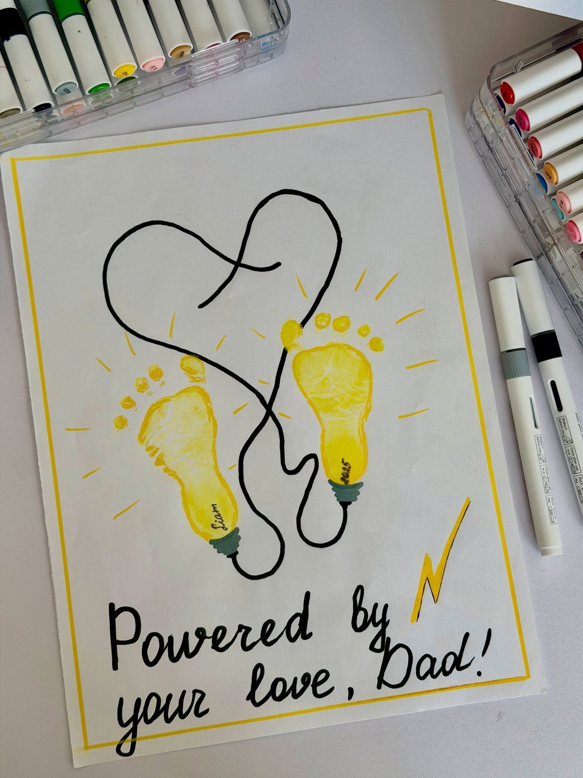 Child's Father's Day craft featuring yellow footprint lightbulbs forming a heart shape.