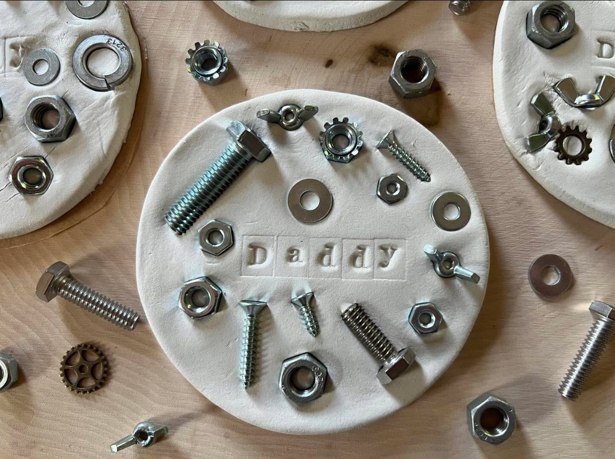 White salt dough discs decorated with metal nuts and bolts for Father's Day.