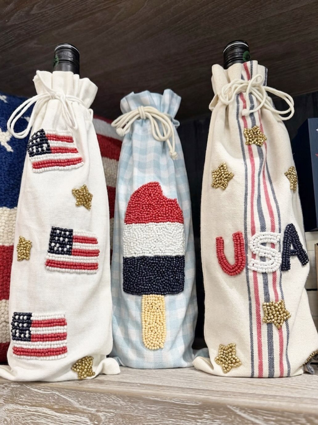 Beaded patriotic wine bottle gift bags featuring American flags and USA lettering.