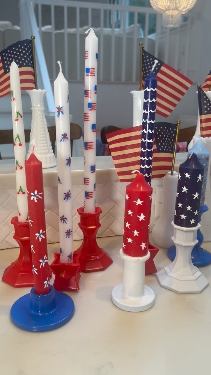 Red, white, and blue decorated taper candles in colorful holders with American flags.