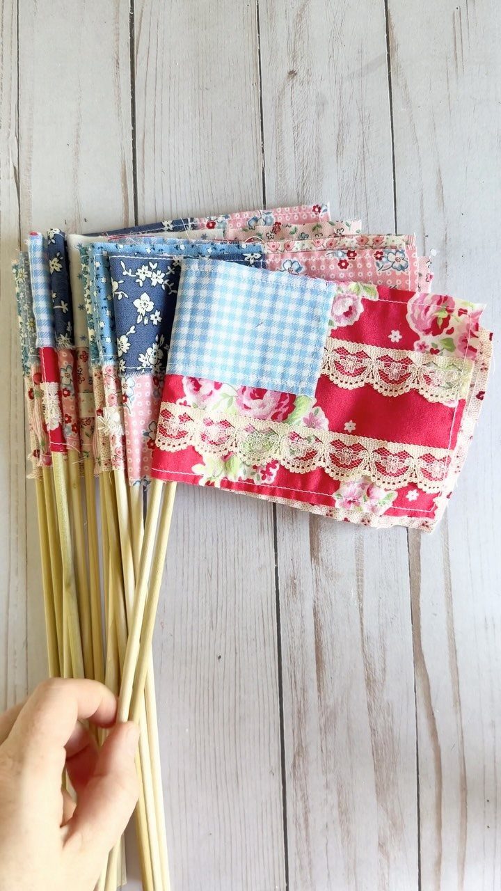 Fabric scrap flags in red, white, and blue held by a hand.