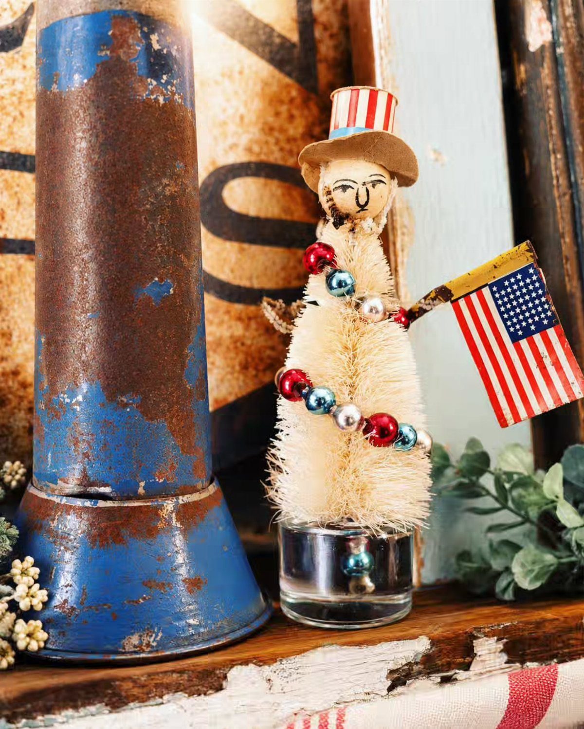Small patriotic figure with a striped top hat holding a tiny American flag