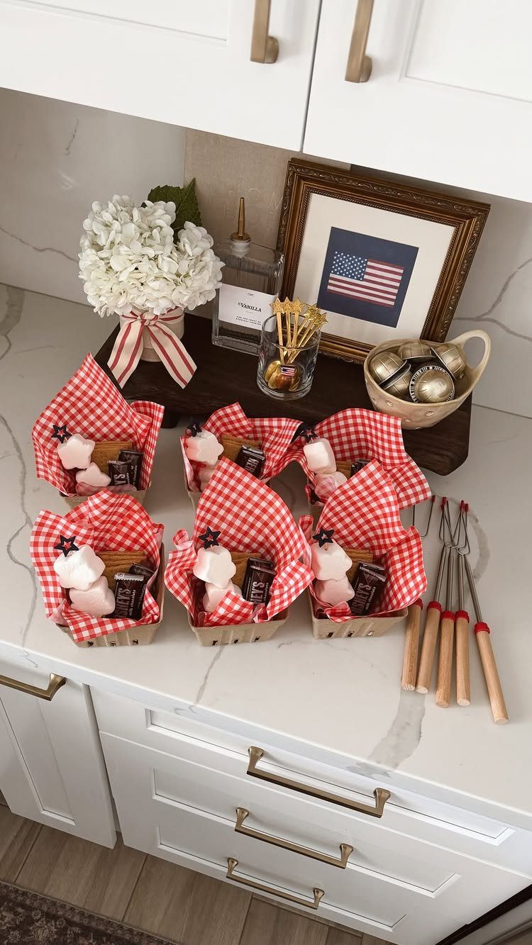 Small snack baskets with red checkered liners and s'mores ingredients on a counter.
