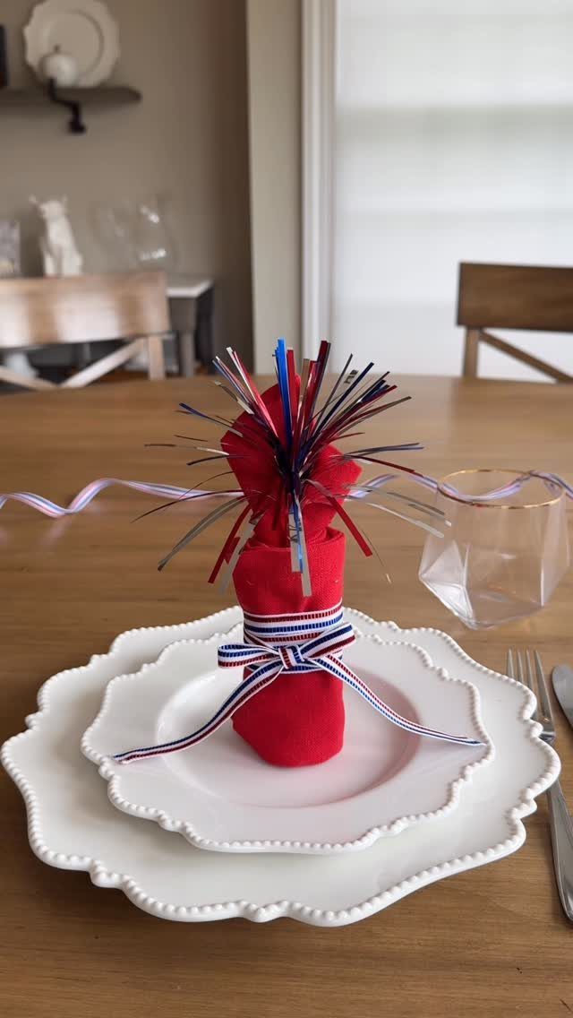 Red napkin with patriotic ribbon and tinsel on white scalloped plates
