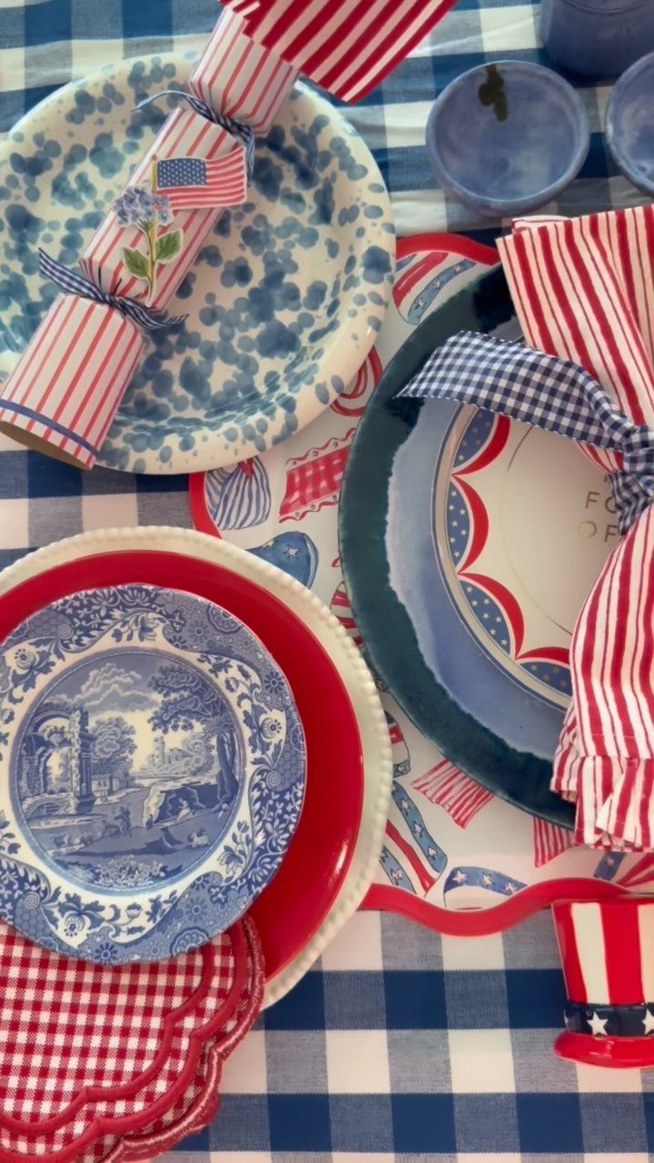 Red and white striped napkins on a blue checkered tablecloth with patriotic dinnerware.