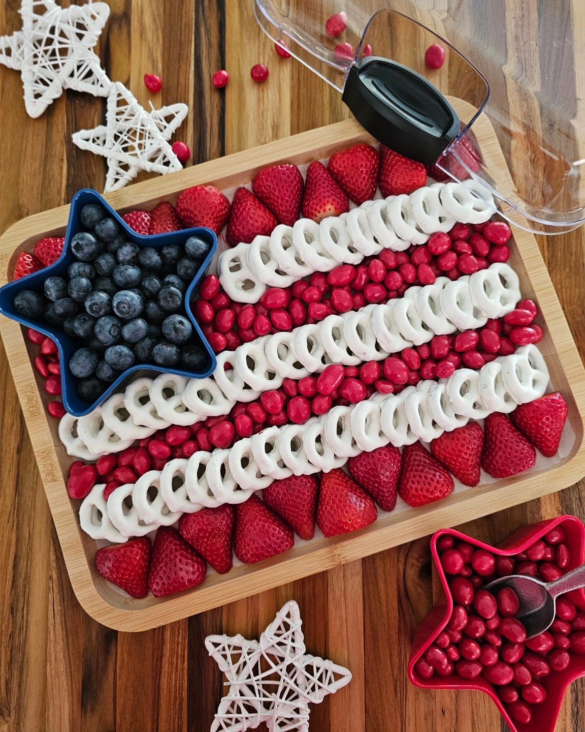 American flag fruit platter with blueberries and strawberries in star-shaped serving dishes.