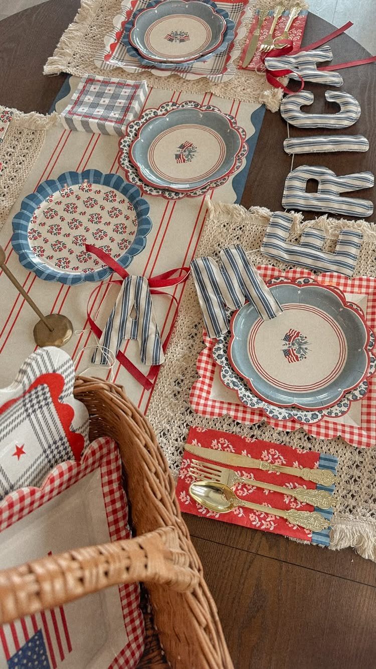 Patriotic table setting with red and blue plates on lace placemats and runners.