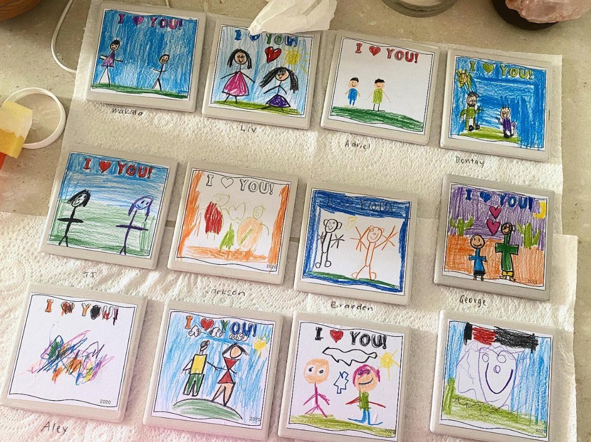 Twelve square ceramic coasters with children's colorful drawings and I love you text.