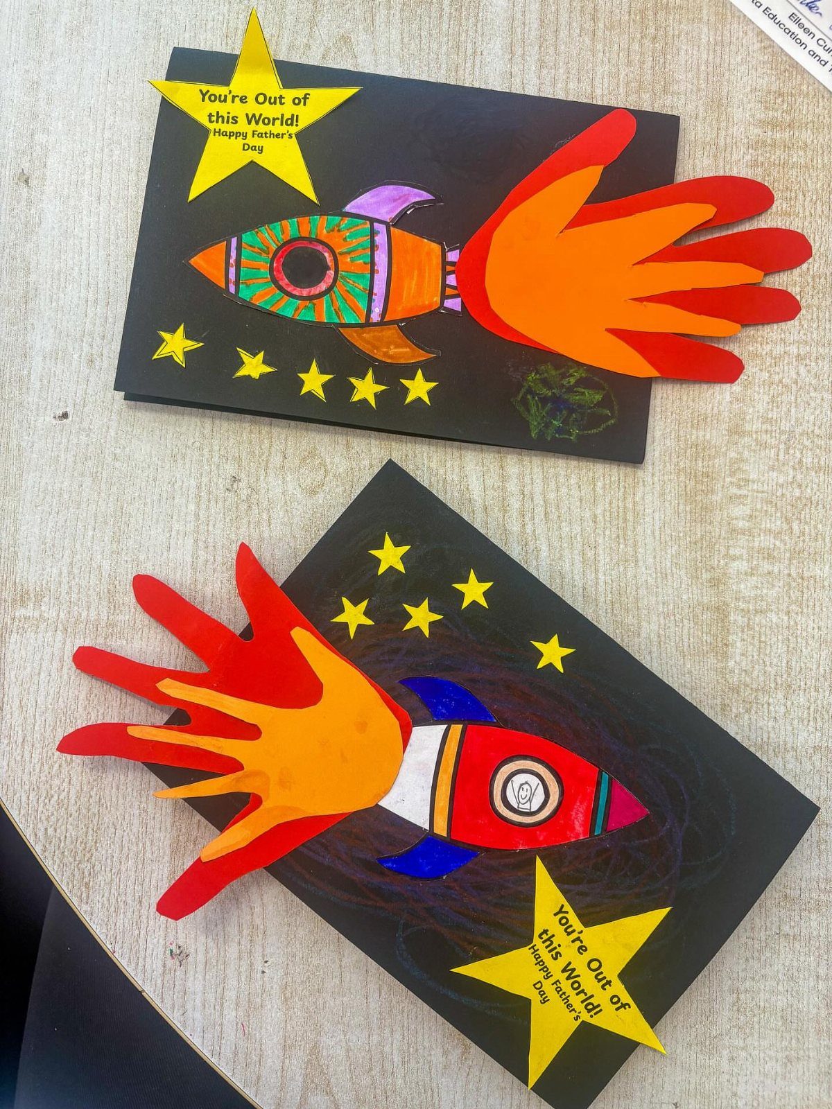 Two handmade Father's Day cards featuring rocket ships made from painted handprints.