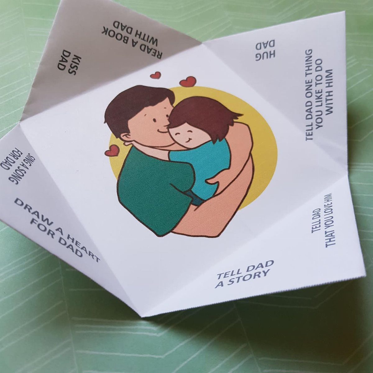 Paper Father's Day craft with an illustration of a father and child hugging.