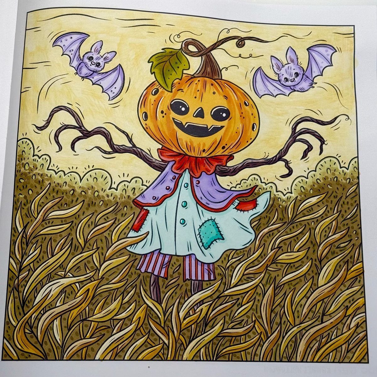Pumpkin headed scarecrow in a cornfield with purple bats in the sky.