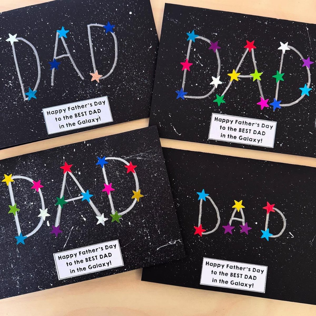 Four space-themed Father's Day cards with colorful star stickers and printed messages.