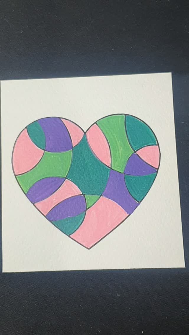 Colored heart with bold black outlines and curved sections on white paper.