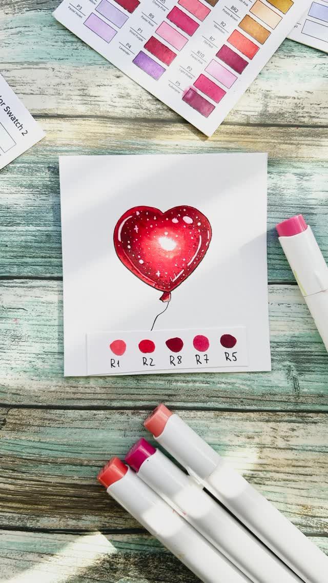 Red heart-shaped balloon drawing on white paper with markers and color swatches.