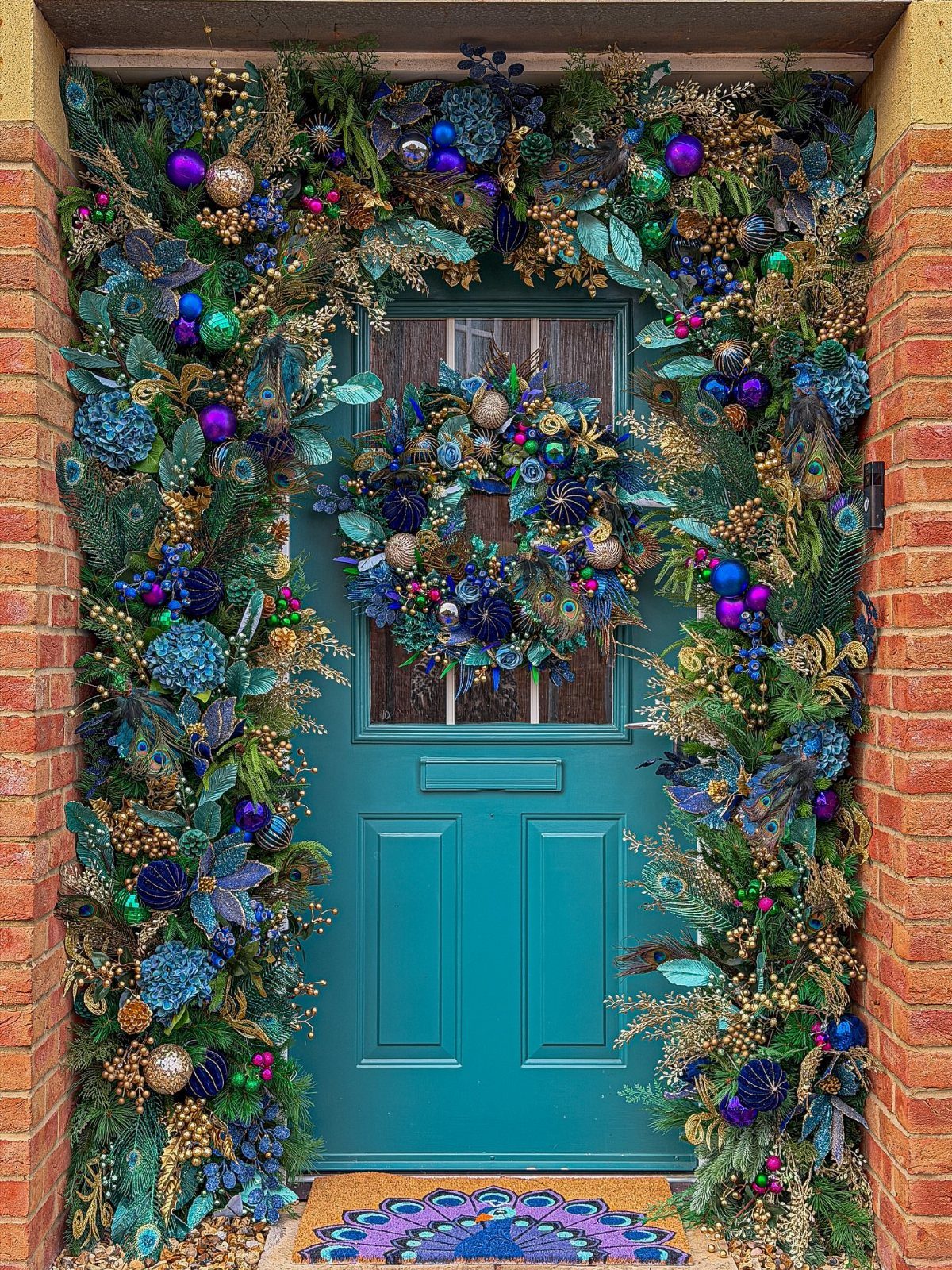 Teal front door with a maximalist wreath and matching garland in blue and purple