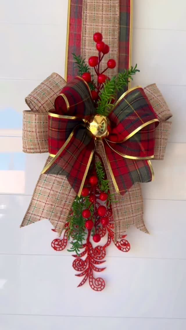 Christmas door bow with red plaid ribbon, burlap, red berries, and gold bell.