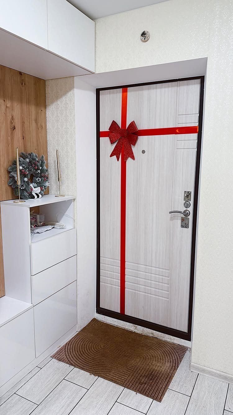 White door wrapped in red ribbons with a large bow like a gift.