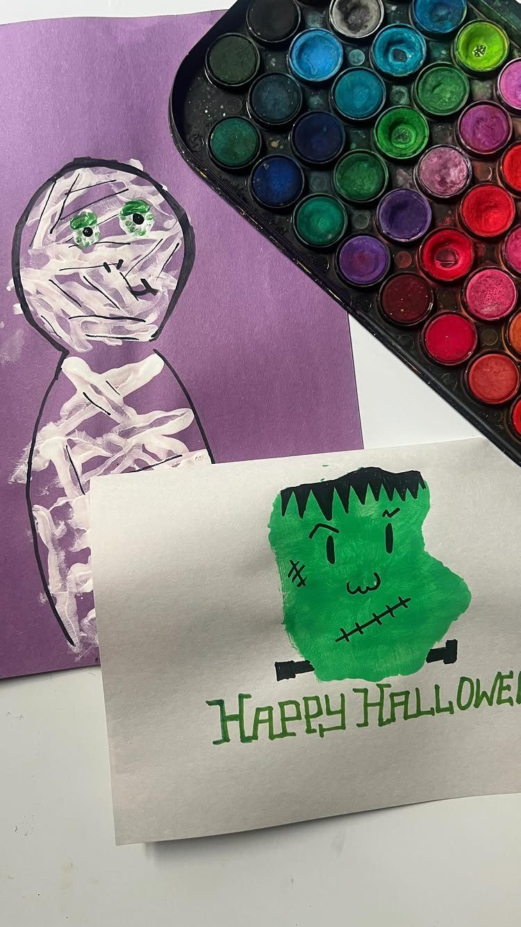 Green handprint painted as Frankenstein's monster on a white Halloween greeting card.