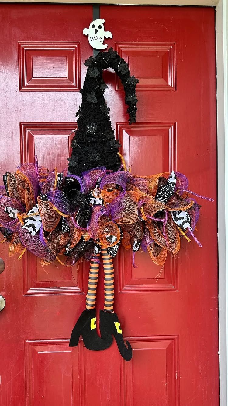 Witch figure with tulle skirt and striped legs decorating a red door