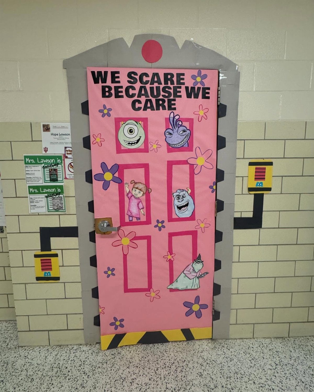 Pink door decorated with Monsters Inc. characters and flowers for a Halloween contest.