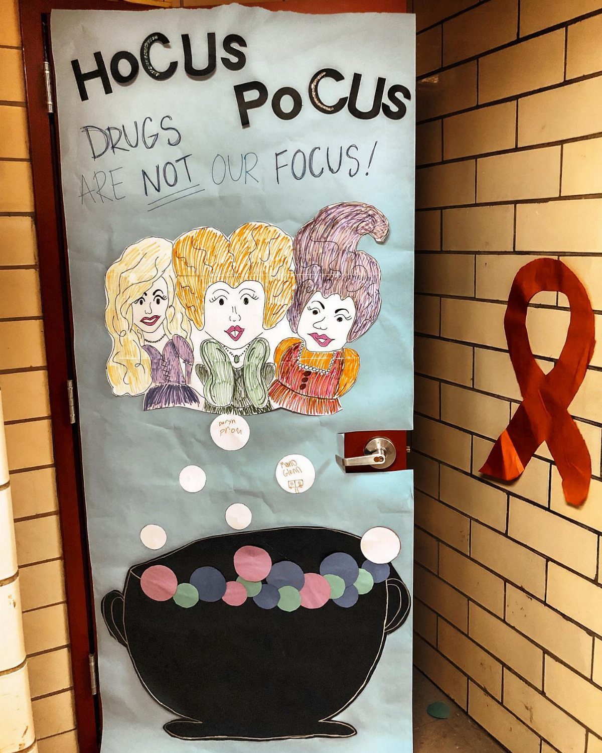 Classroom door decorated with Hocus Pocus witches and a black cauldron illustration.