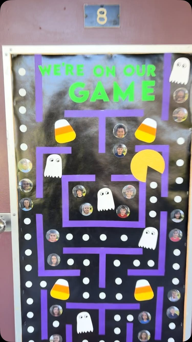 Classroom door decorated as a Pac-Man game with ghosts, candy corn, and student photos.