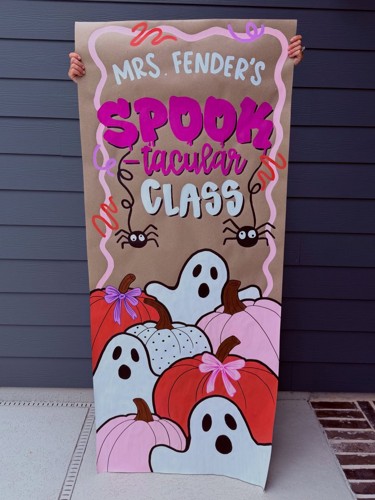Halloween door decoration with ghosts, pumpkins, and text for Mrs. Fender's Spooktacular Class.