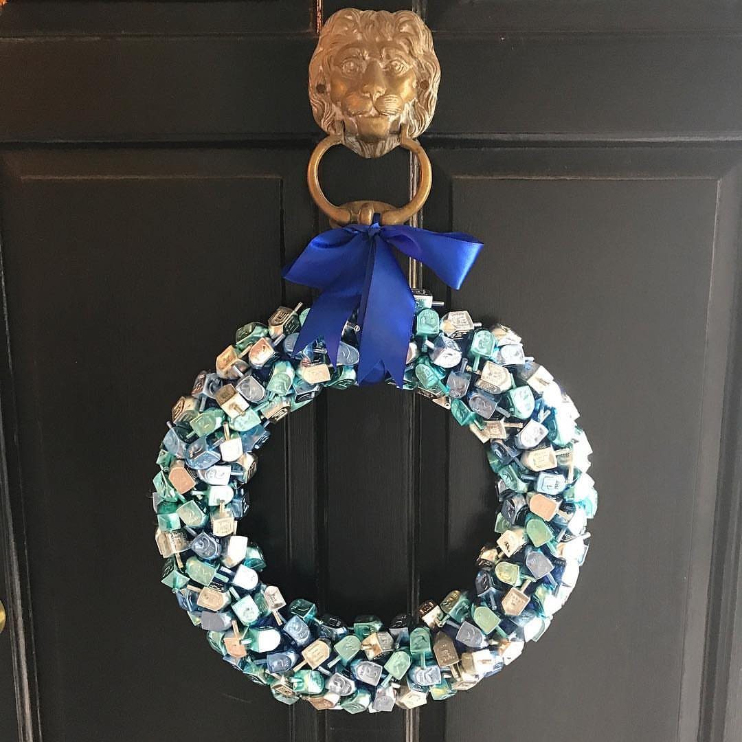Candy wreath made of blue and silver wrapped sweets hanging on a door
