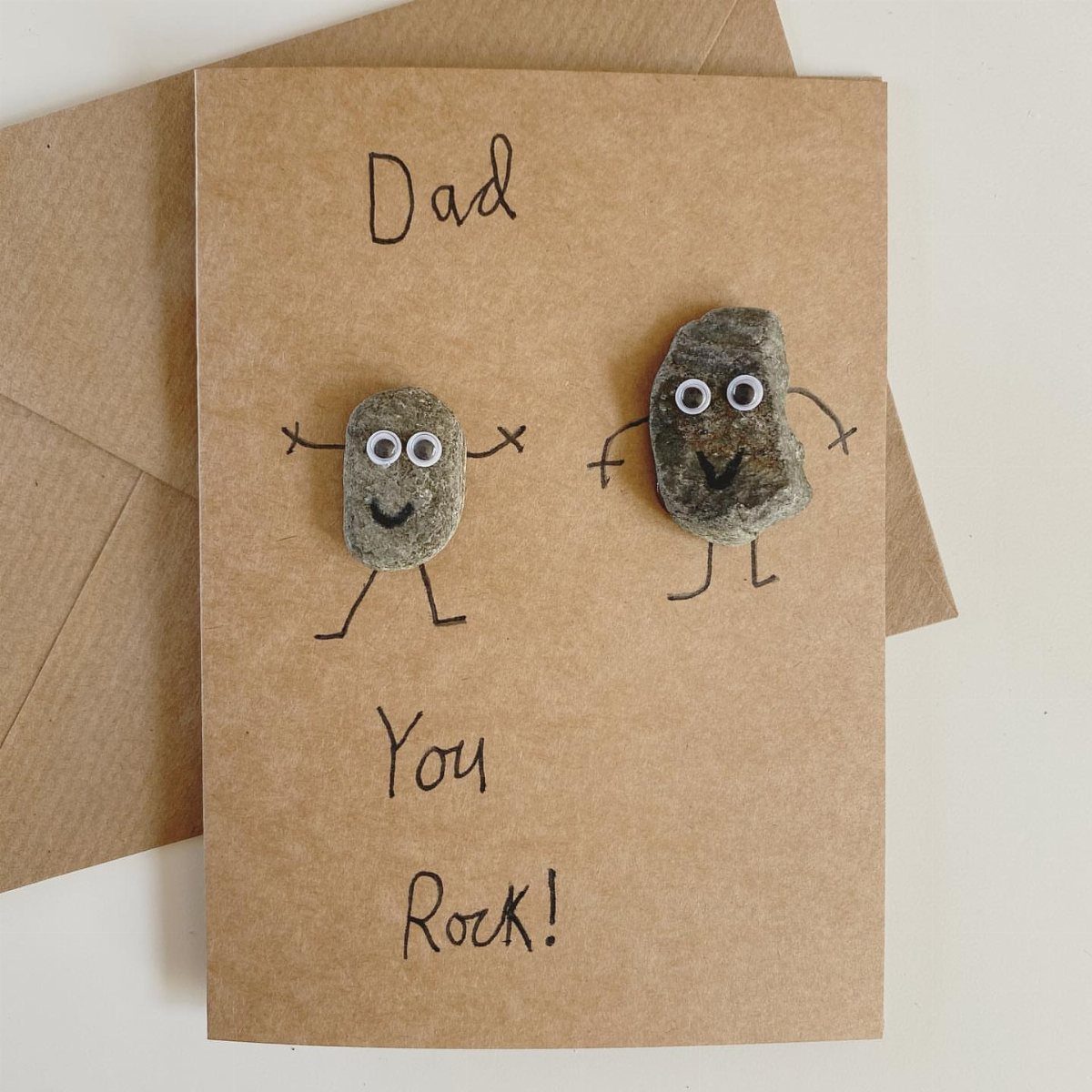 Handmade Father's Day card with two small rocks as characters and text.