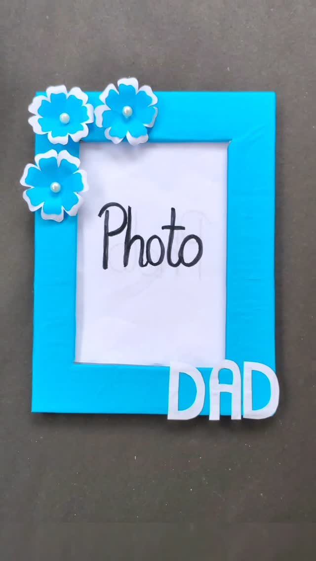 Blue handmade picture frame decorated with flowers and the word DAD for Father's Day.