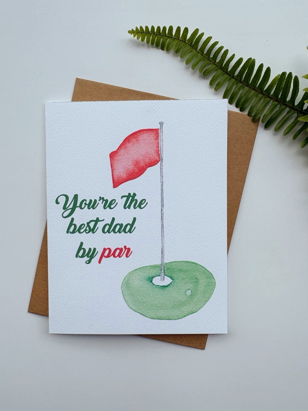 Watercolor Father's Day card with a golf flag and punny text on white paper.