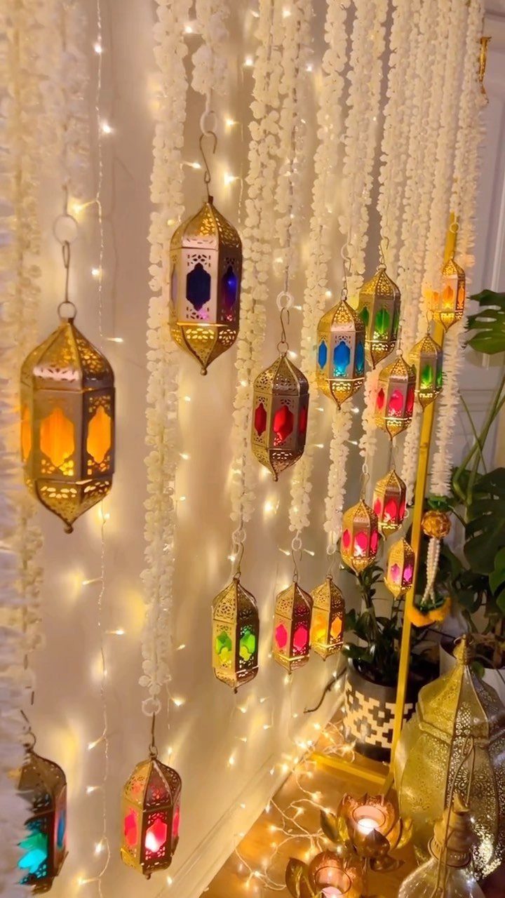 Gold decorative lanterns hanging with white floral garlands and warm fairy lights.