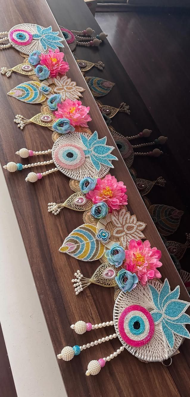 Decorative toran door hanging with blue evil eyes and pink flowers on wood