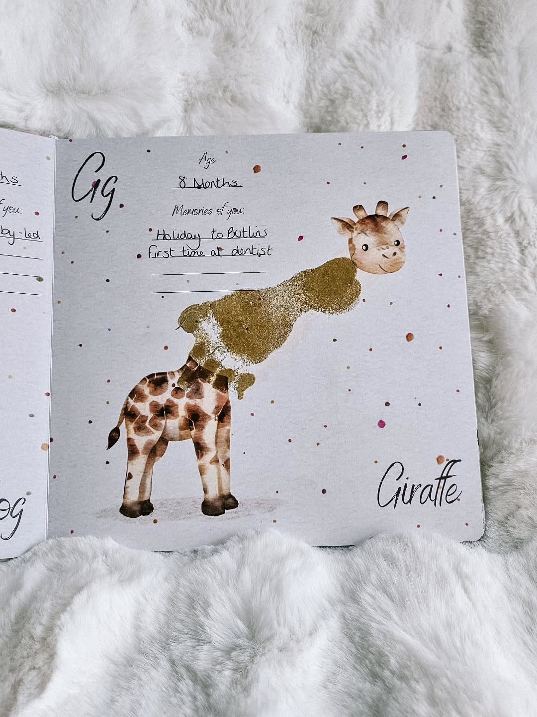 Baby memory book page with a giraffe made from a gold handprint.