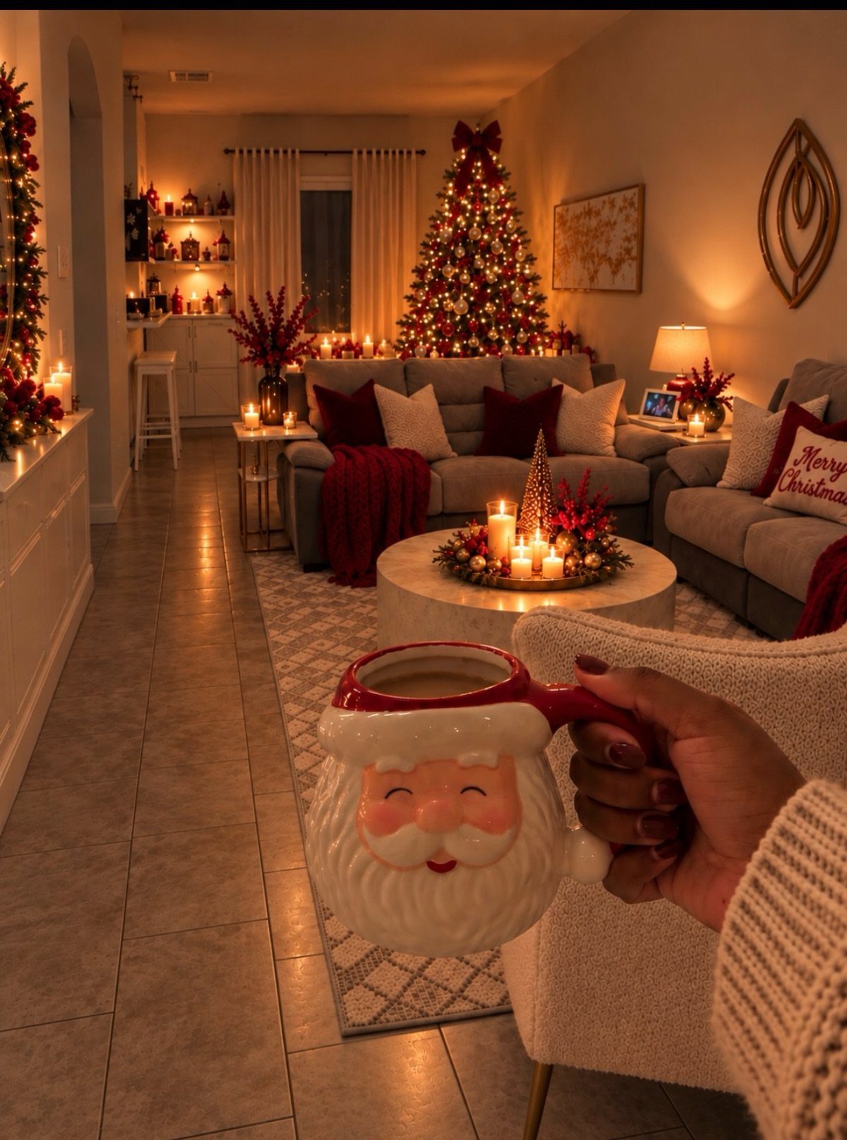 Santa mug held in foreground of a cozy Christmas living room with red textiles.
