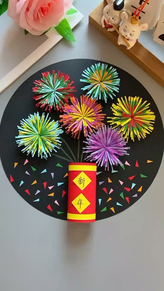Firecracker craft with colorful paper fireworks on a black circular background.