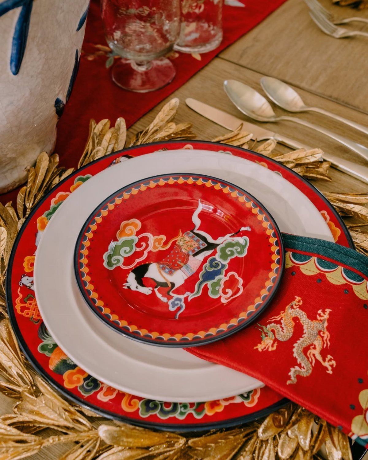 Lunar New Year table setting with red dragon plates and gold leaf charger.