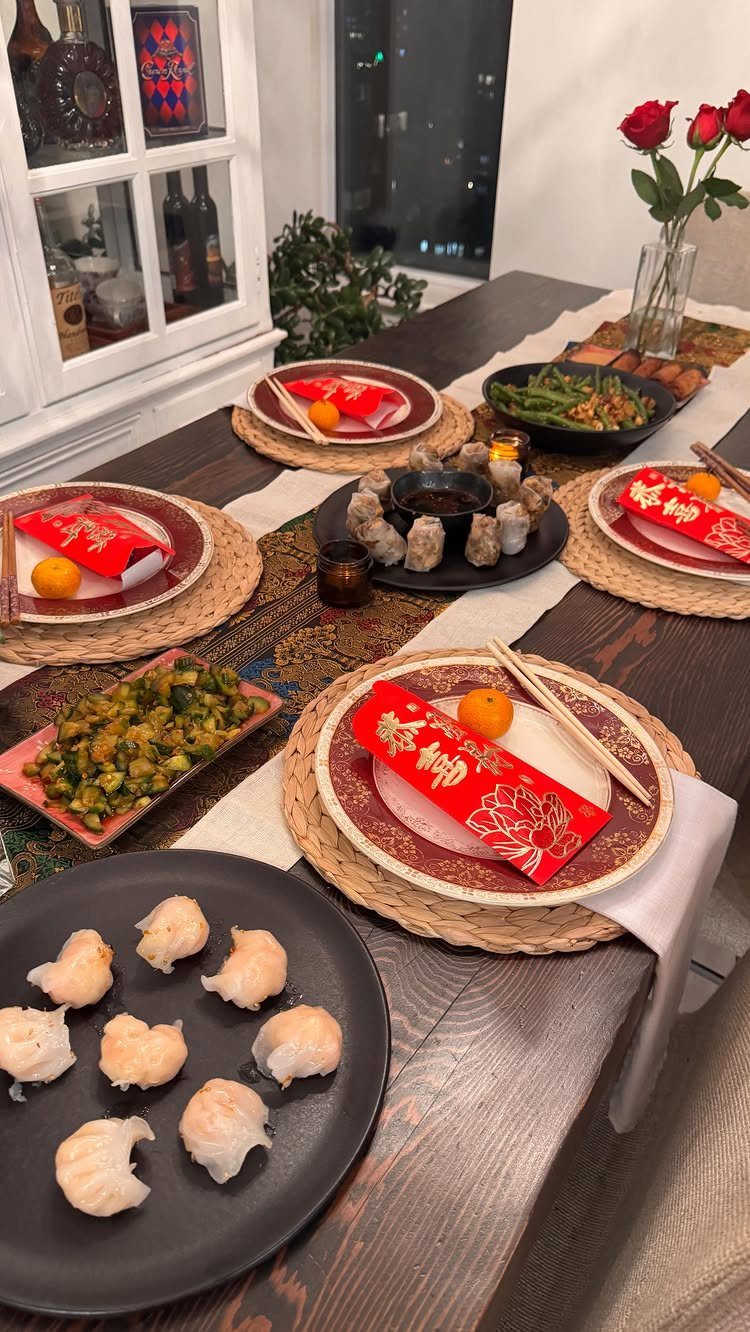Lunar New Year table setting with red envelopes, dim sum, and gold plates.