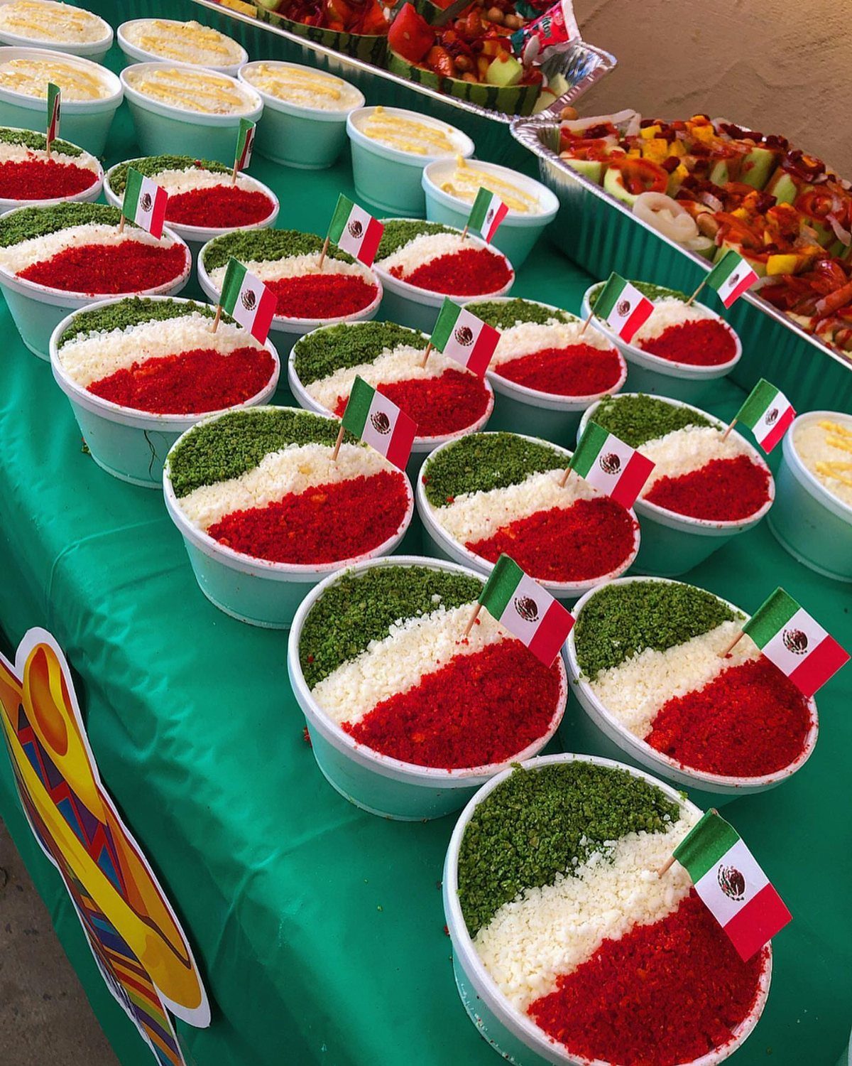 Layered red, white, and green food bowls with small Mexican flag picks.
