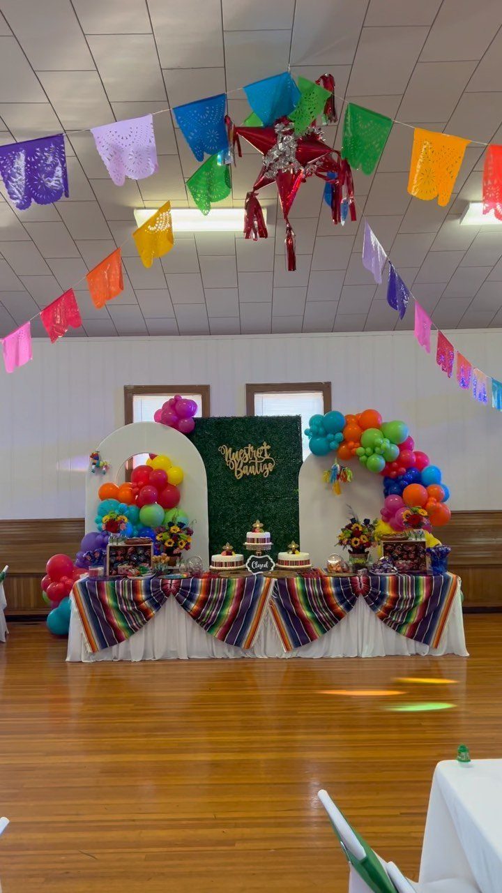 Colorful striped serape runners decorating a party table with balloons and banners.